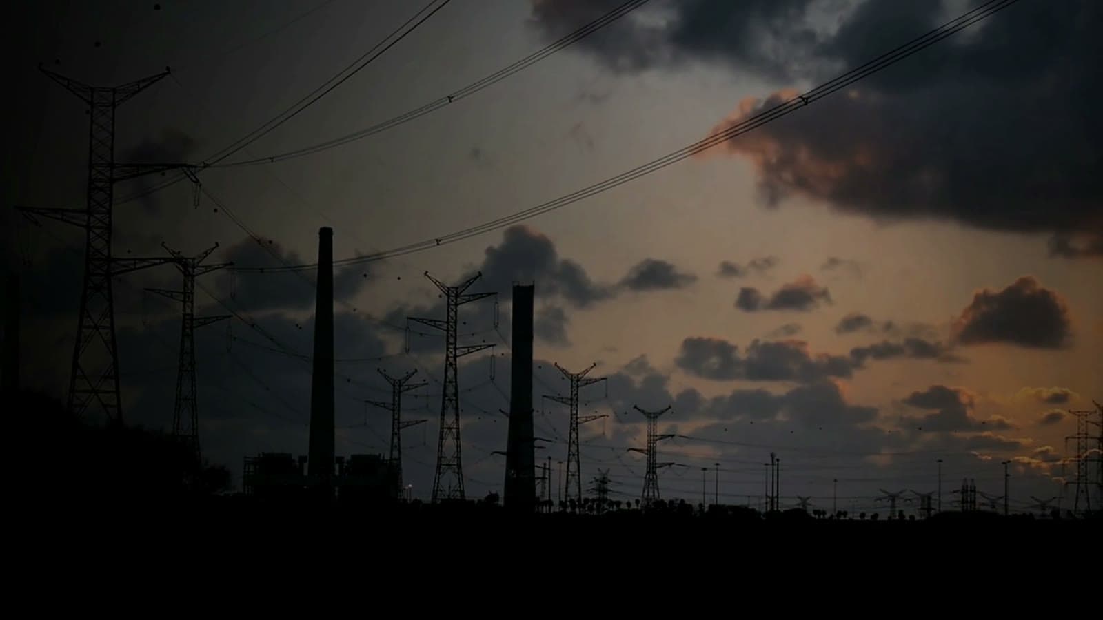 Transmission pylons and power lines against a dusk sky